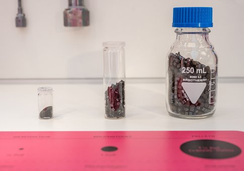 Nahaufnahme dreier Ausstellungsstücke. Kleine Pellets befinden sich in Gläsern.